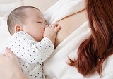 A redheaded woman breastfeeding her infant