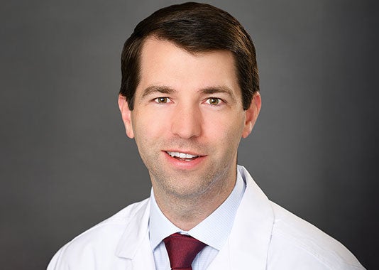 Professional headshot of orthopedic surgeon Dr. Peter Johnston Shaughnessy, MD, smiling in white lab coat.