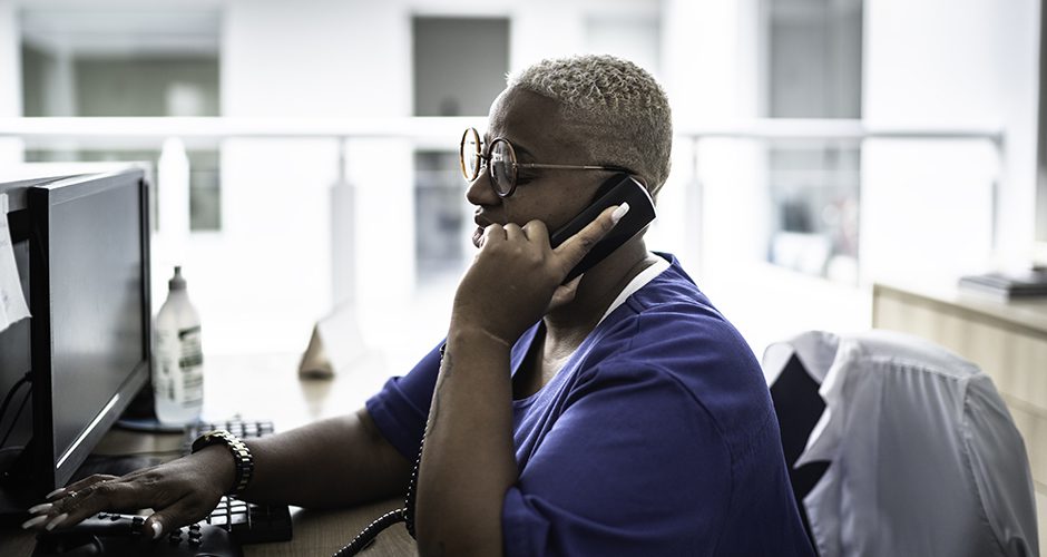 Secretary talking on telephone at hospital reception