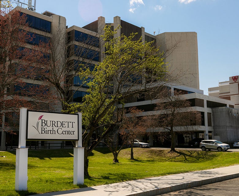 Exterior image of Burdett Birth Center main entrance, showing logo on sign and connection to Samaritan Hospital.