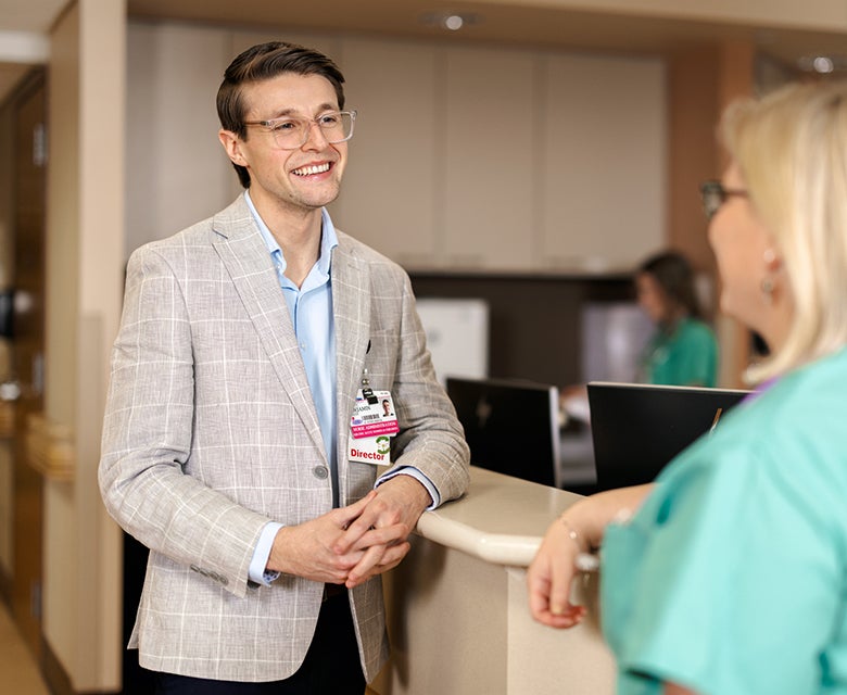 Nurse Ben Pinzer, Director of Burdett Birth Center, speaks with an experienced nurse manager near the open reception area.